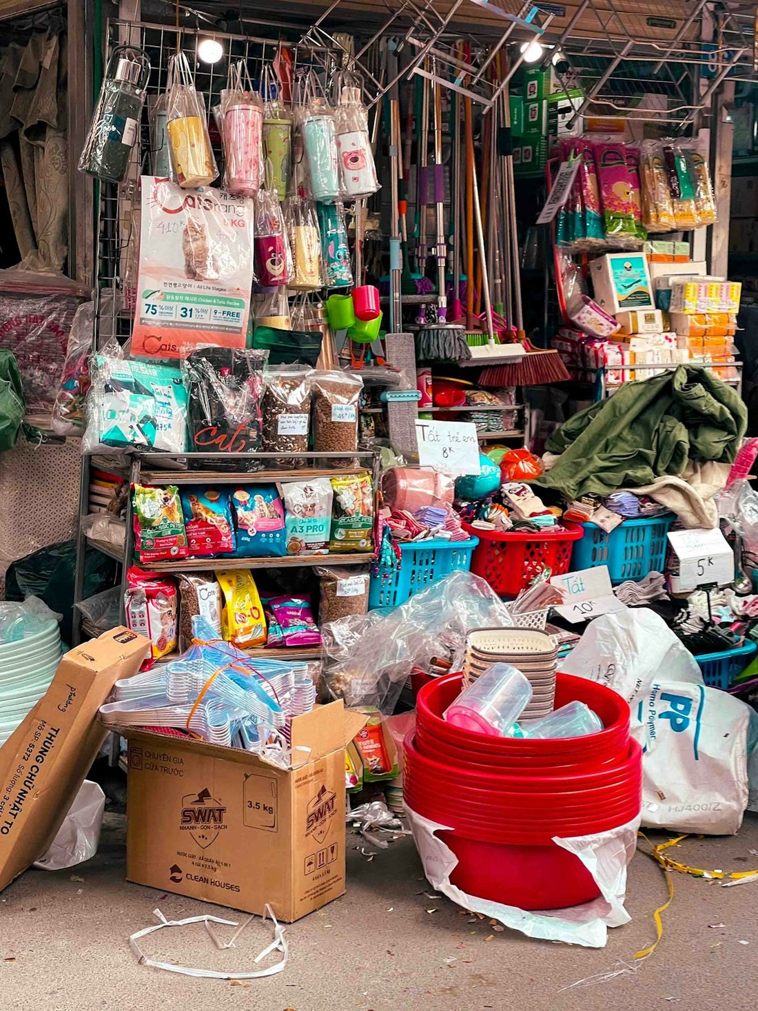 A cluttered stall selling various household goods and supplies